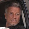 O ator Marcello Novaes está dentro de um carro, com expressão séria, na série Justiça 2 como Egisto