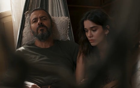 Em cena de Renascer, Marcos Palmeira está deitado na rede com Theresa Fonseca ao lado